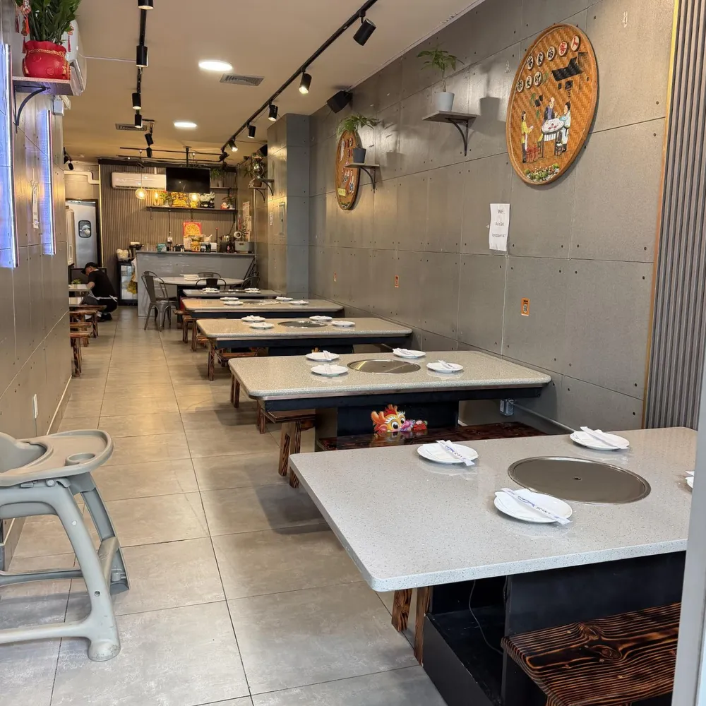 Neatly arranged indoor dining area with hot pot tables at Xu's grill, a Chinese Restaurant in Flushing