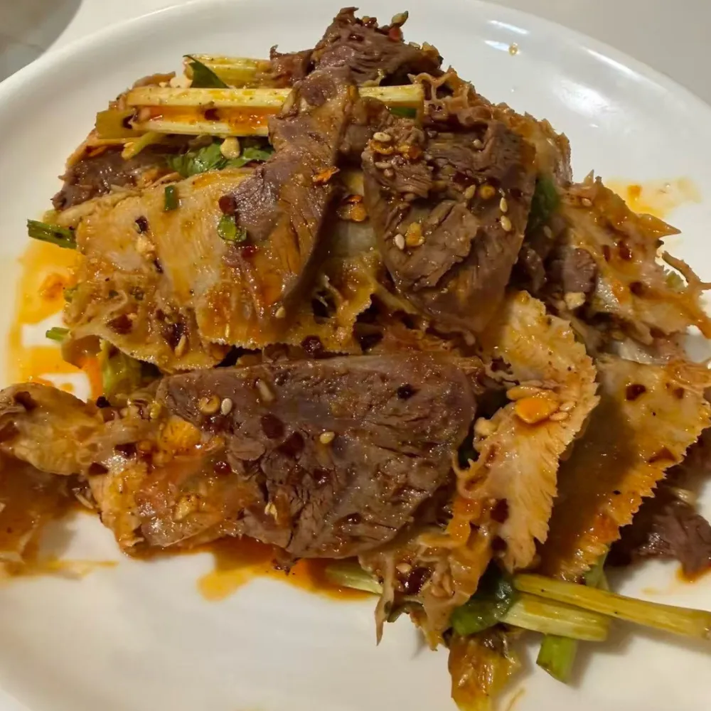 Spicy sliced beef and ox tripe mixed with sesame and greens at Xu's grill, a Chinese Restaurant in Flushing